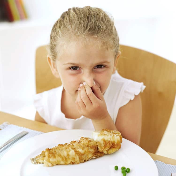 Young Girl (13-14) Holding Her Nose at the Dinner Table