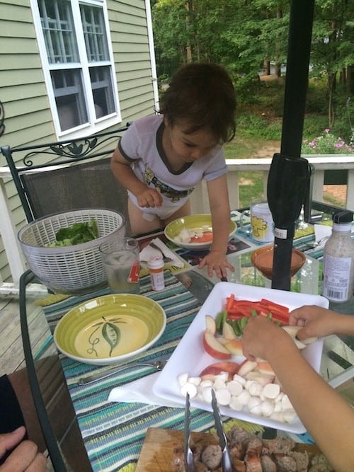 Young Kid serving themselves food during family style dining