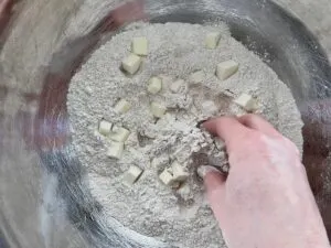 hands in bowl combining ingredients