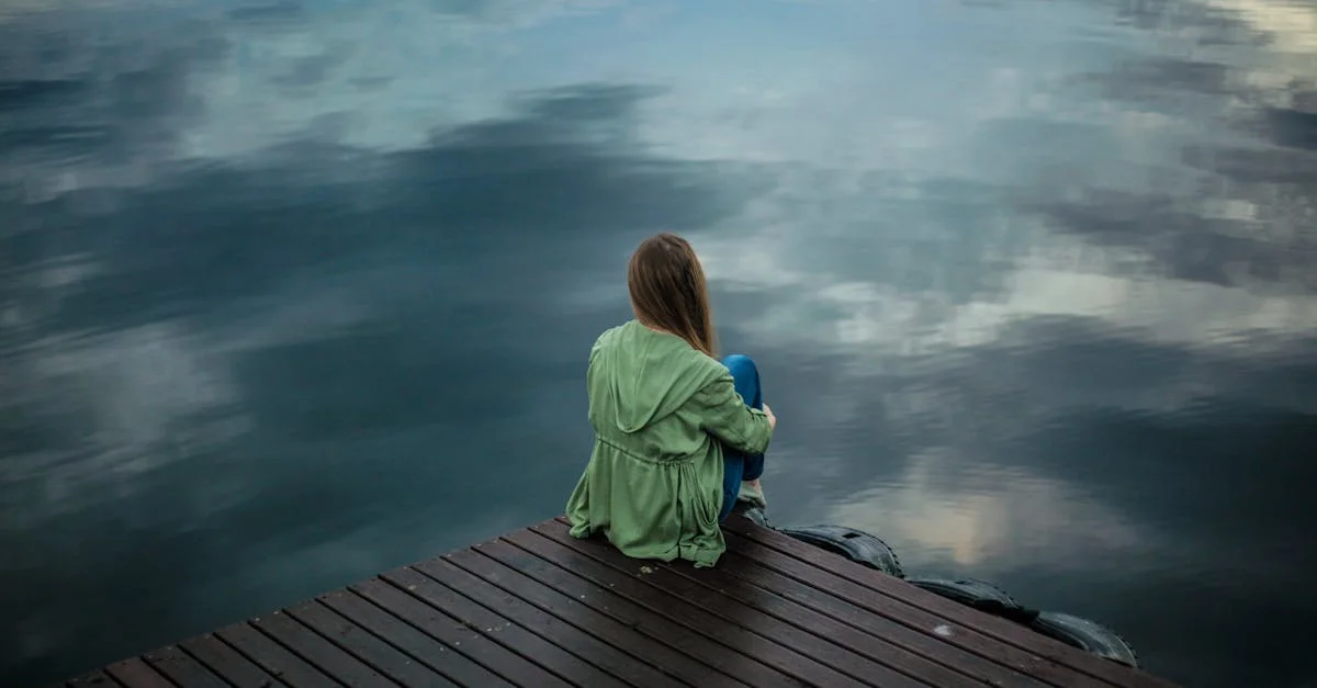 woman sitting by lake: is it normal to be sad about reaching menopause?