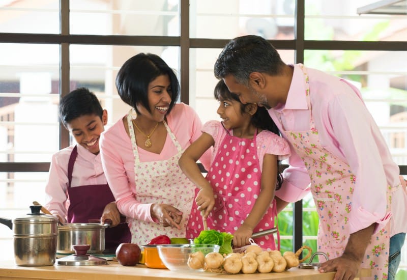 A family cooking together in the kitchen, learning techniques side by side